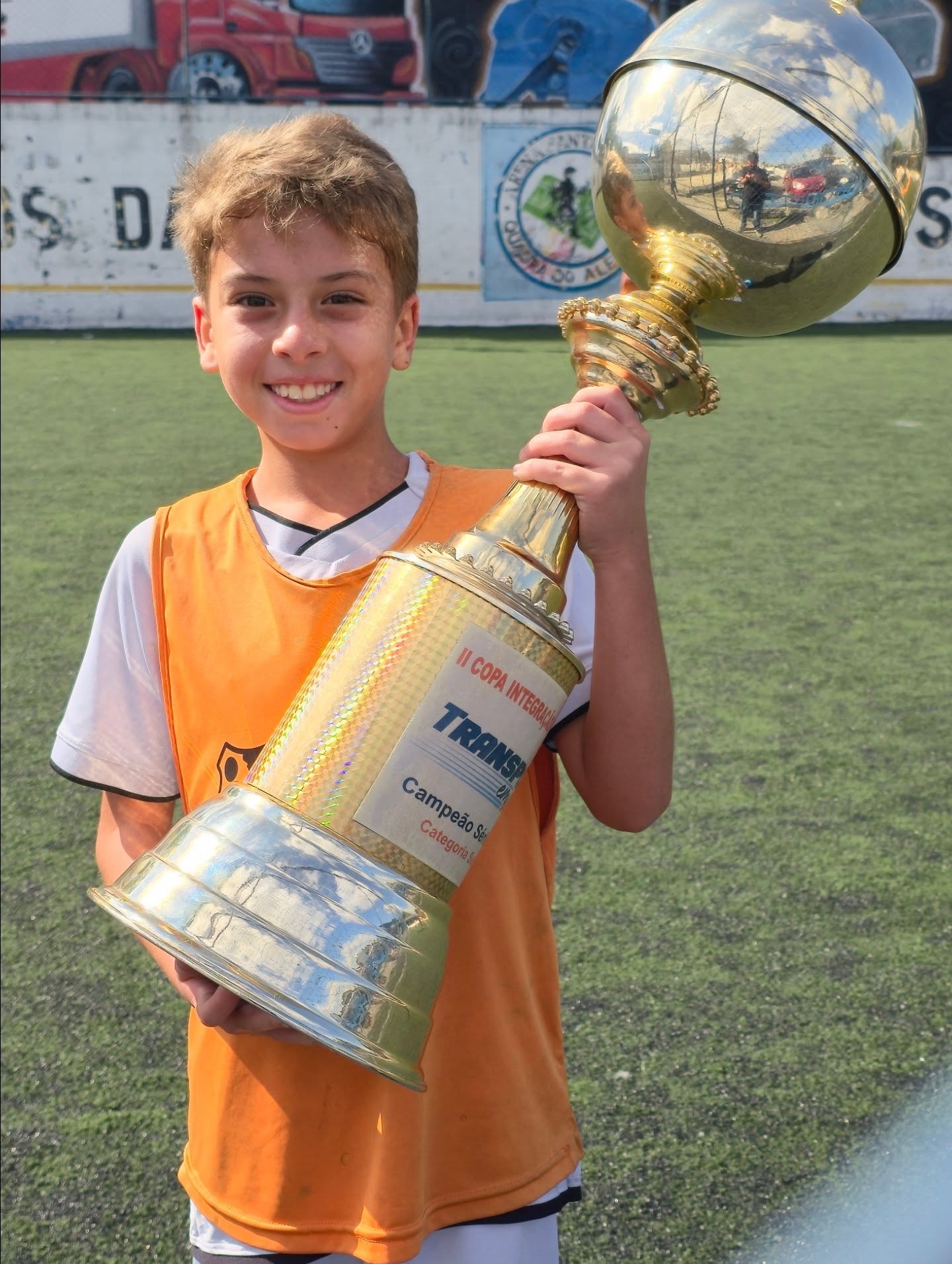 Aluno comemorando título com o troféu