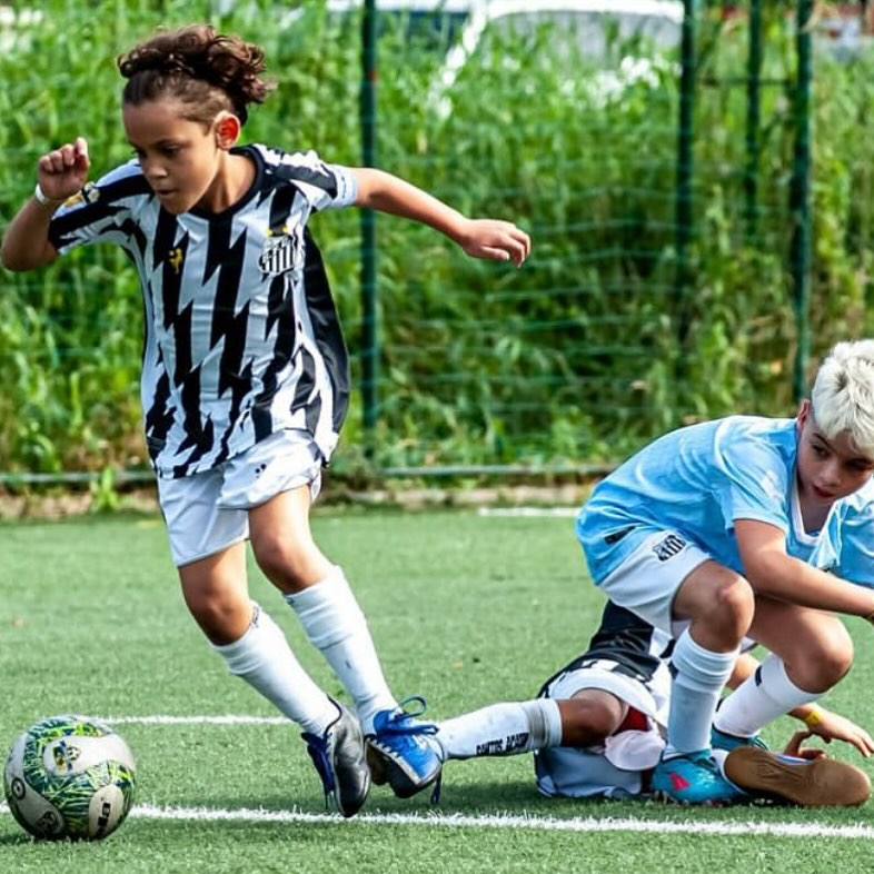 Aluno do Sub-11 conduzindo a bola em jogo